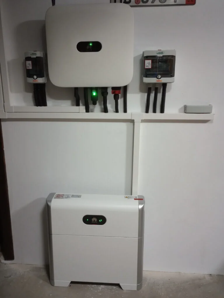 Zestaw falownika hybrydowego trójfazowego i Magazyn energii do domu zamontowany na ścianie z widocznymi kablami